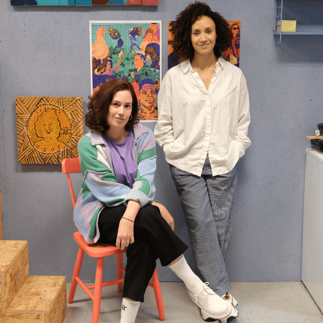 Hedy Tjin zittend en Zindzi Zevenbergen staand, in hun atelier